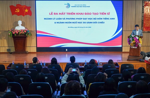 A group of people sitting in chairs in front of a screenDescription automatically generated